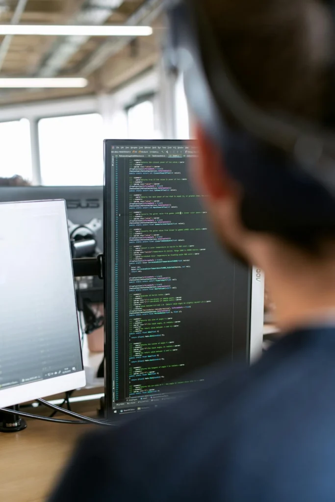 Programador analizando código en pantalla, representando los 10 años de experiencia de Open Ximdex Evolution en proyectos innovadores de gestión de datos y contenidos.